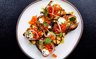 Open face baked potato with fish roe, sour cream, pickled onion and more
