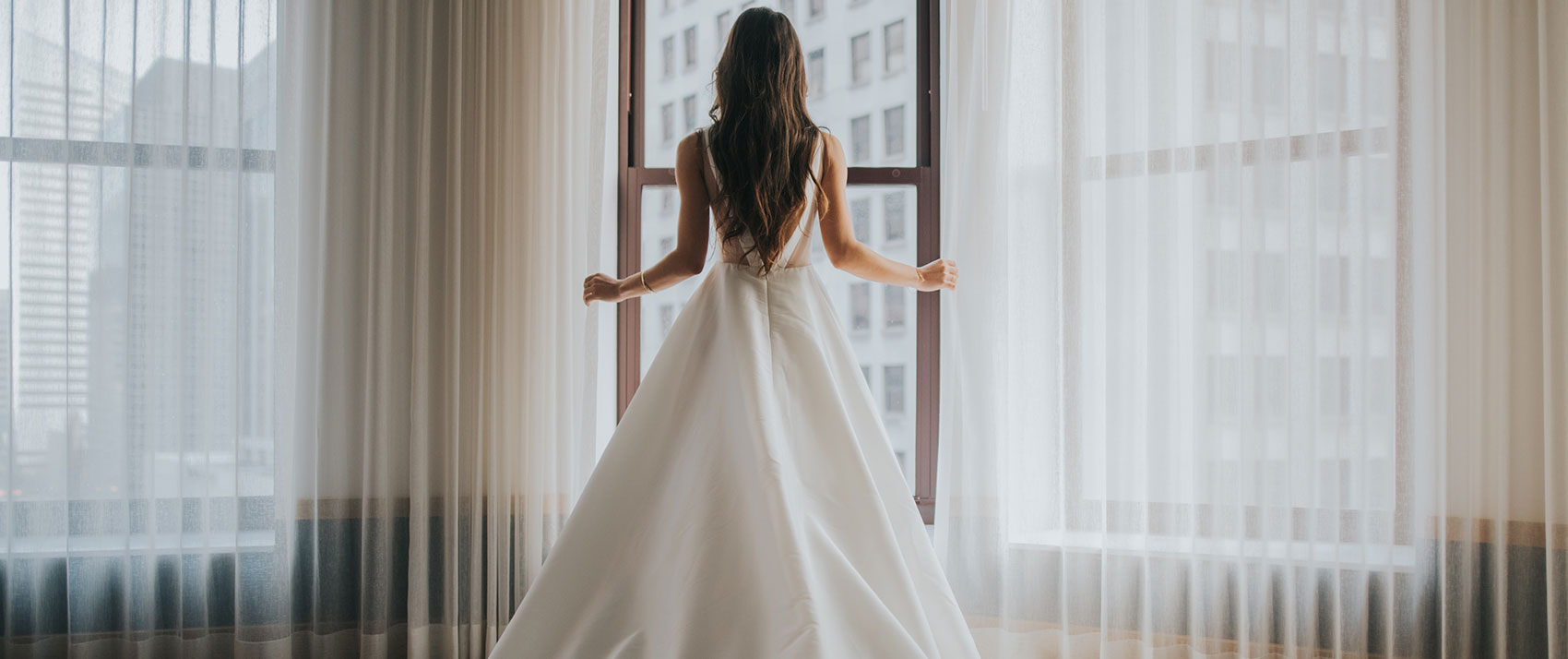 bride standing at window overlooking downtown